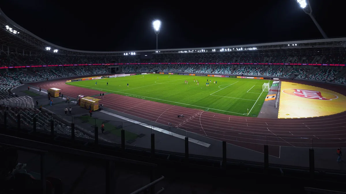Match de football en direct dans un grand stade sous les projecteurs